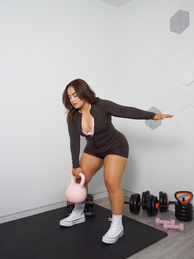 The coach is working out with the kettlebell.