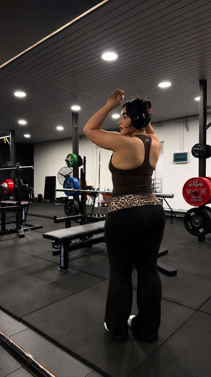 Coach is posing next to to workout equipments.