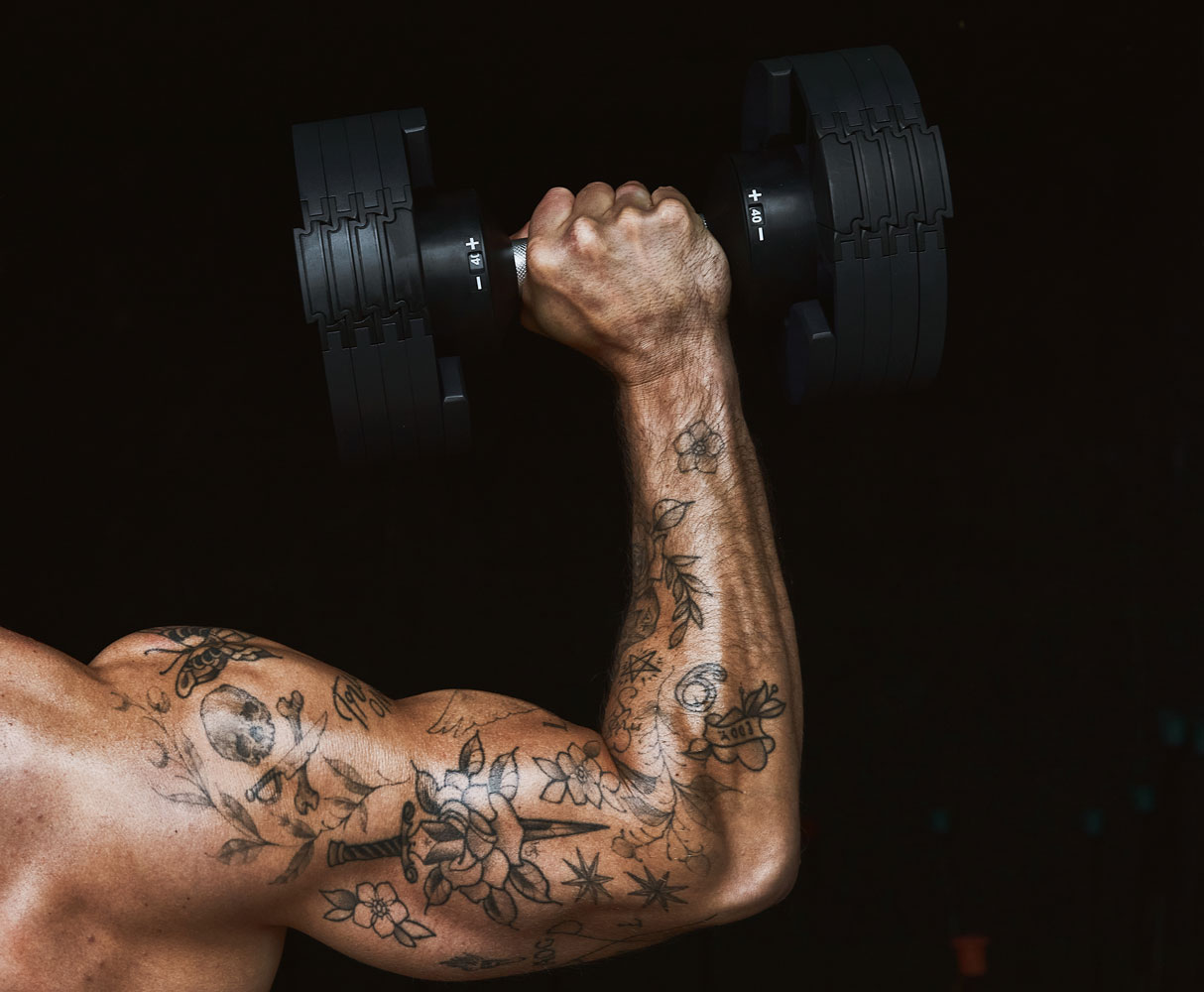 The coach's arm has tatoos.