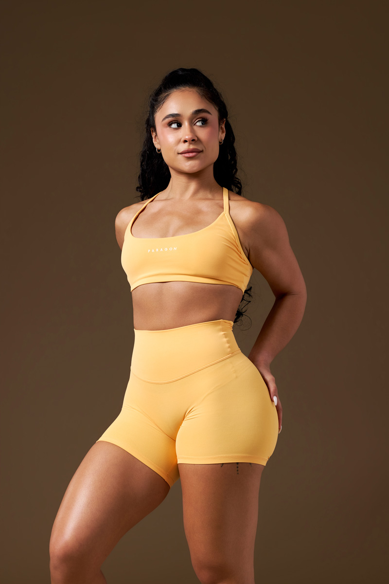 The coach is posing while wearing yellow clothing.