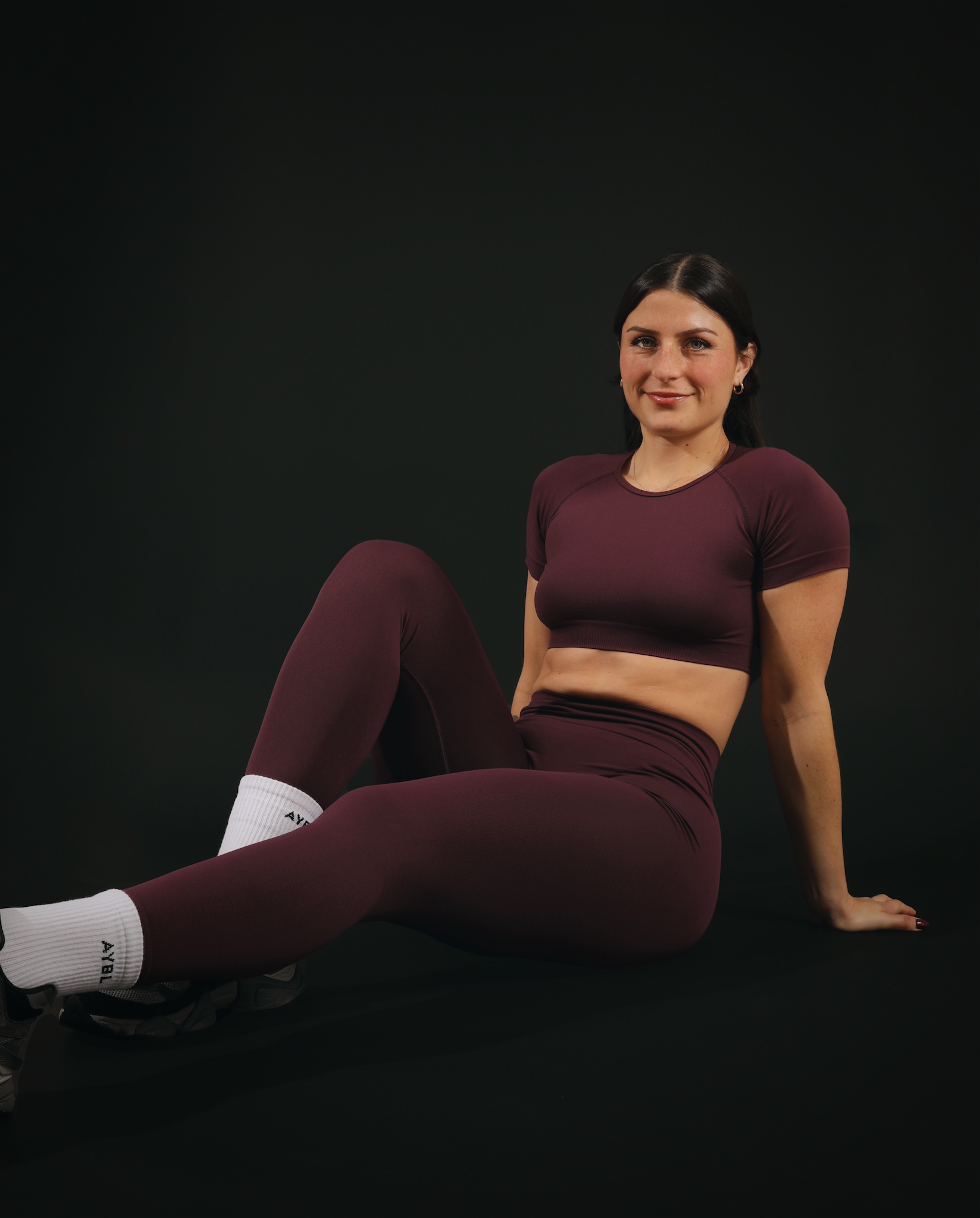 Coach is posing in a brown workout outfit.