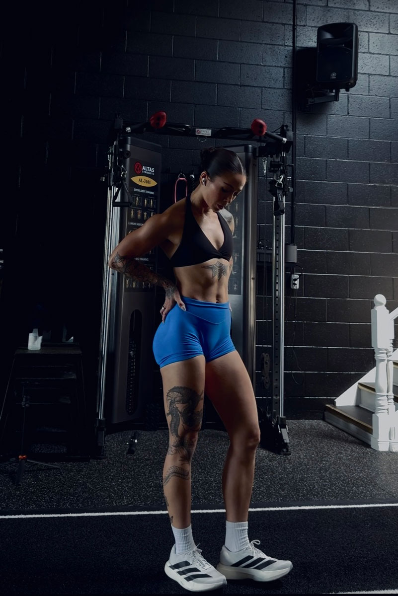 The coach is posing at the gym.