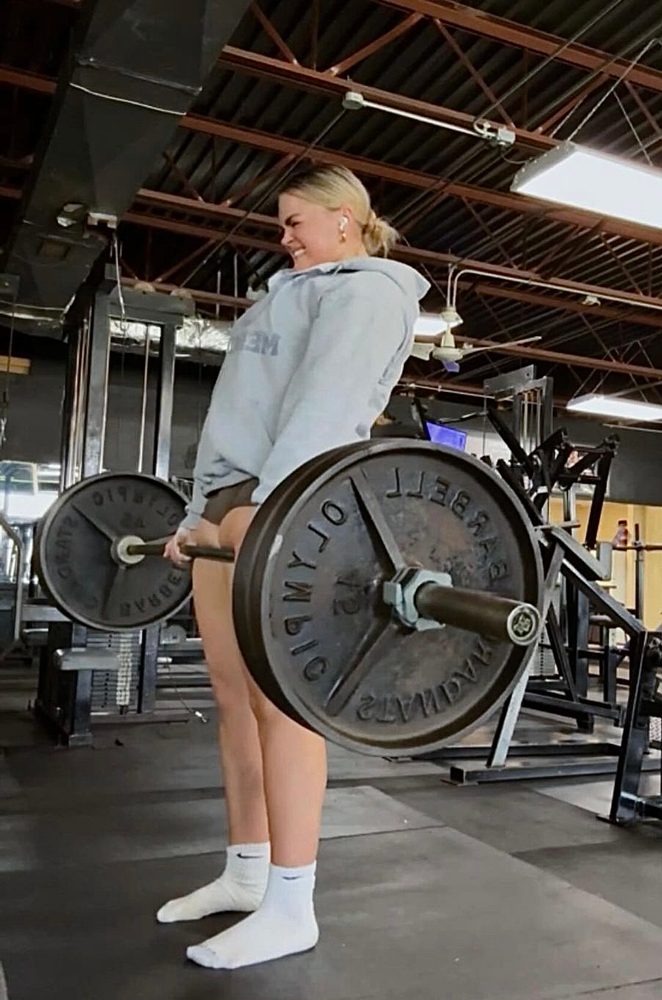 The coach is working out while holding the weights.