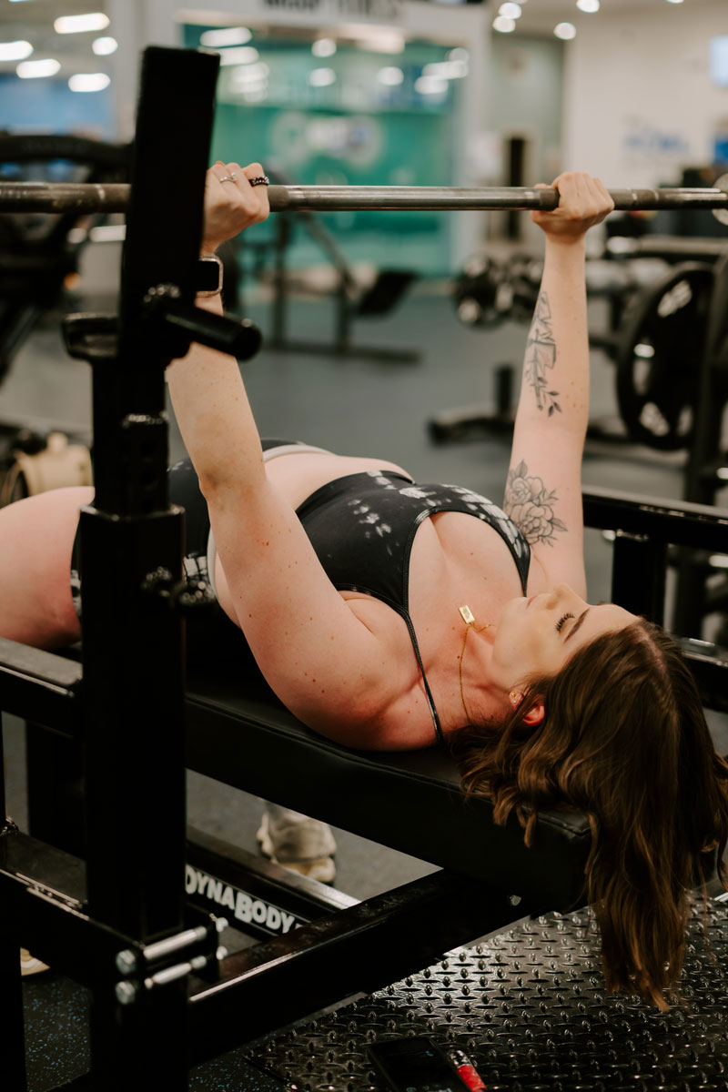 The coach is doing the bench press.