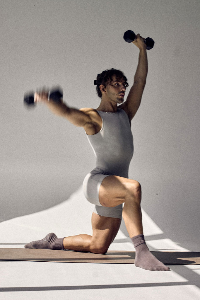 The coach is holding the dumbbells.