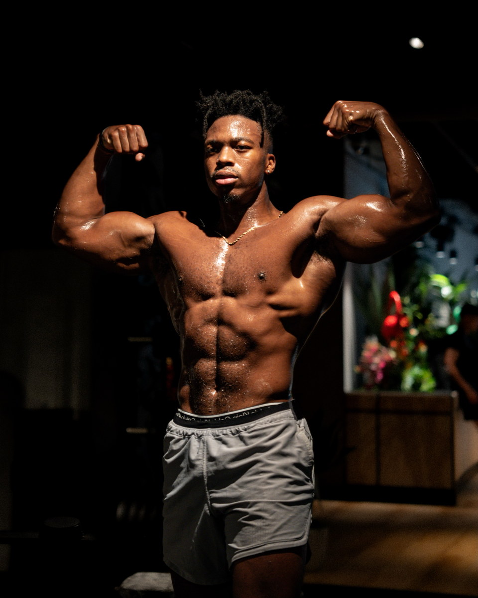 The coach is showing his muscle with two arms.