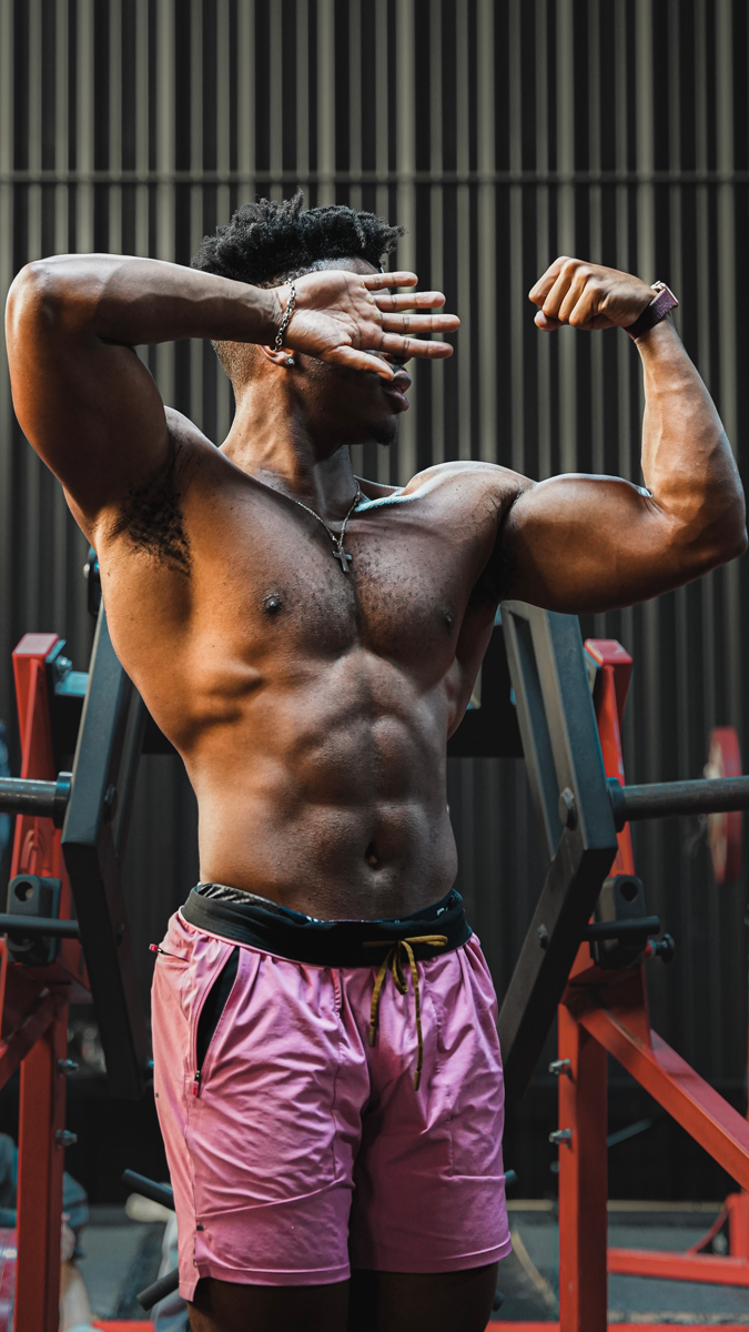 The coach is showing his muscle while wearing pink pants.