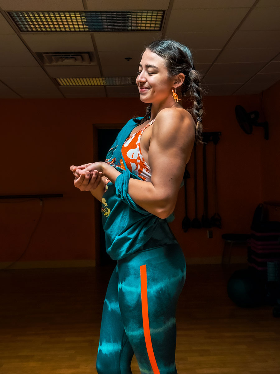 The female coach is posing while smiling.