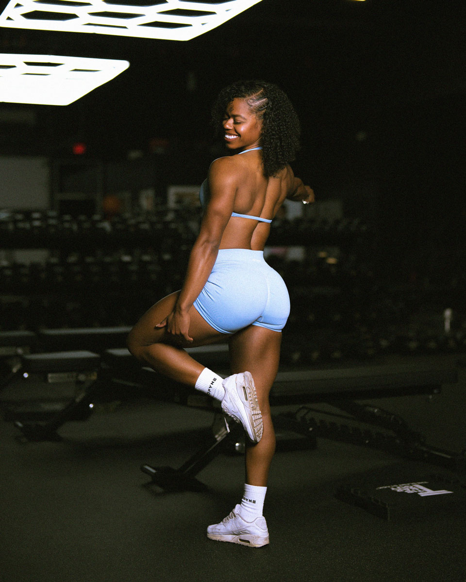 The coach is back posing at the gym.
