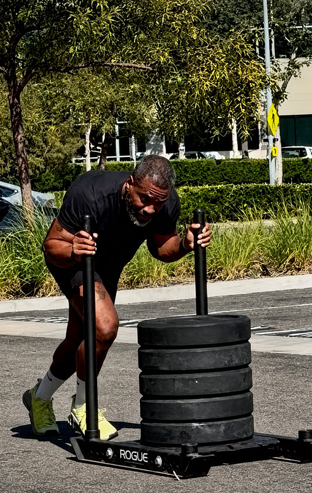 The coach is holding the weights.