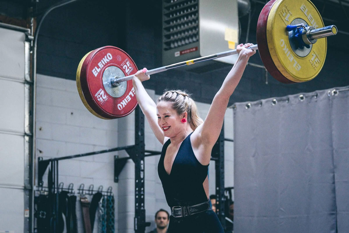 Coach is lifting a weigth at a competition.