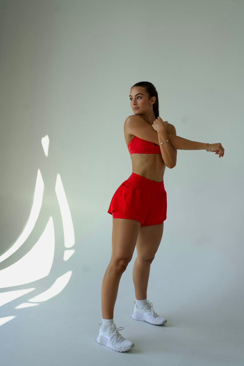 The coach is posing while wearing the red clothing.