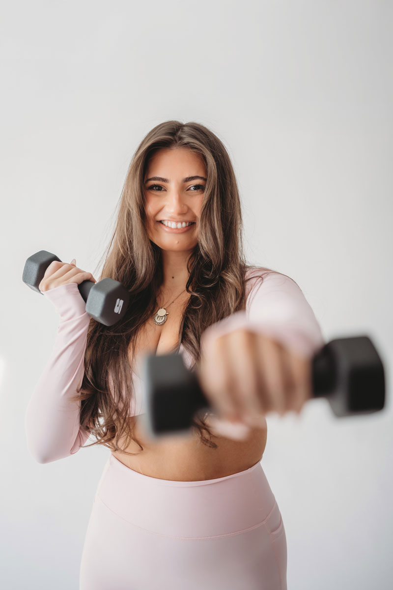 The coach is posing while holding the dumbbells.