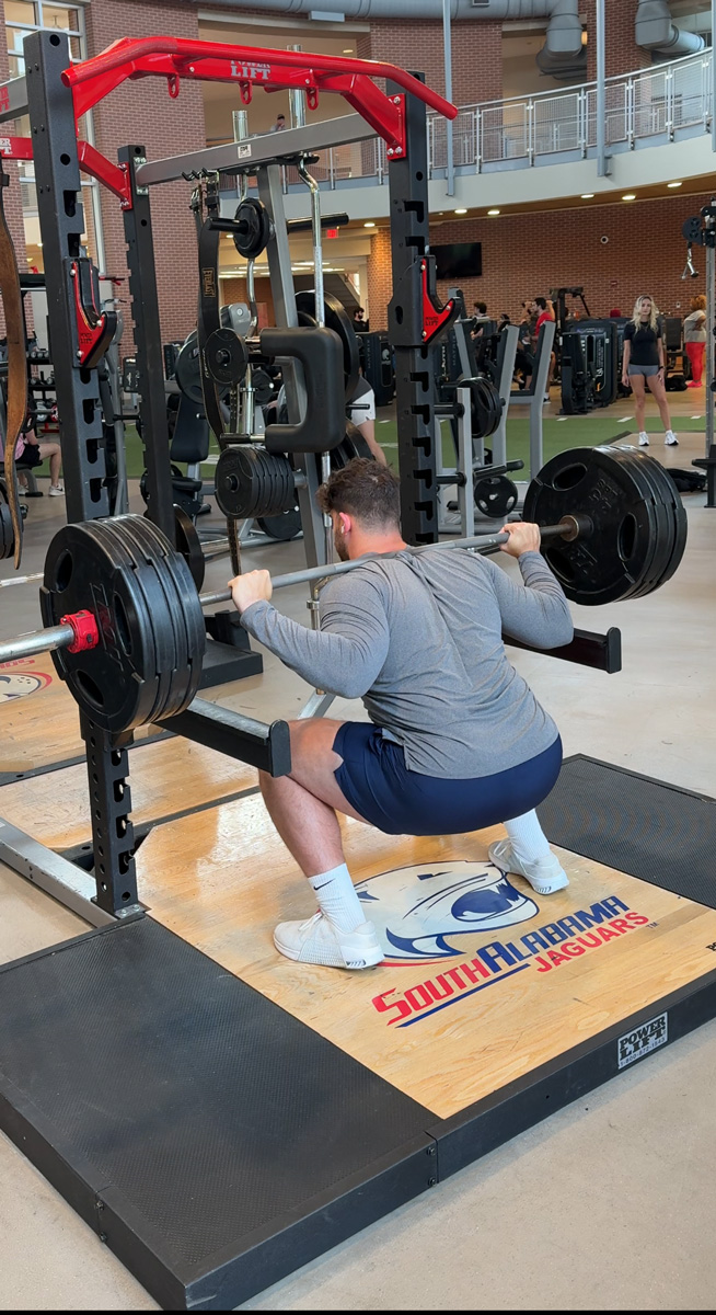 The coach is holding the weights.