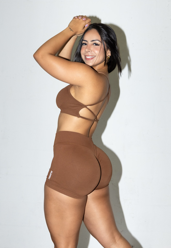 Coach is posing with a brown workout outfit.