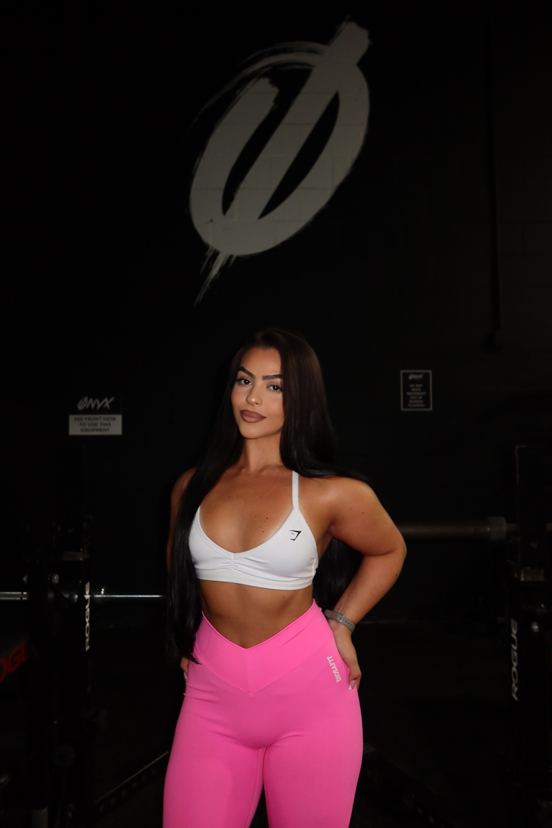 Coach smiling and posing in the gym.