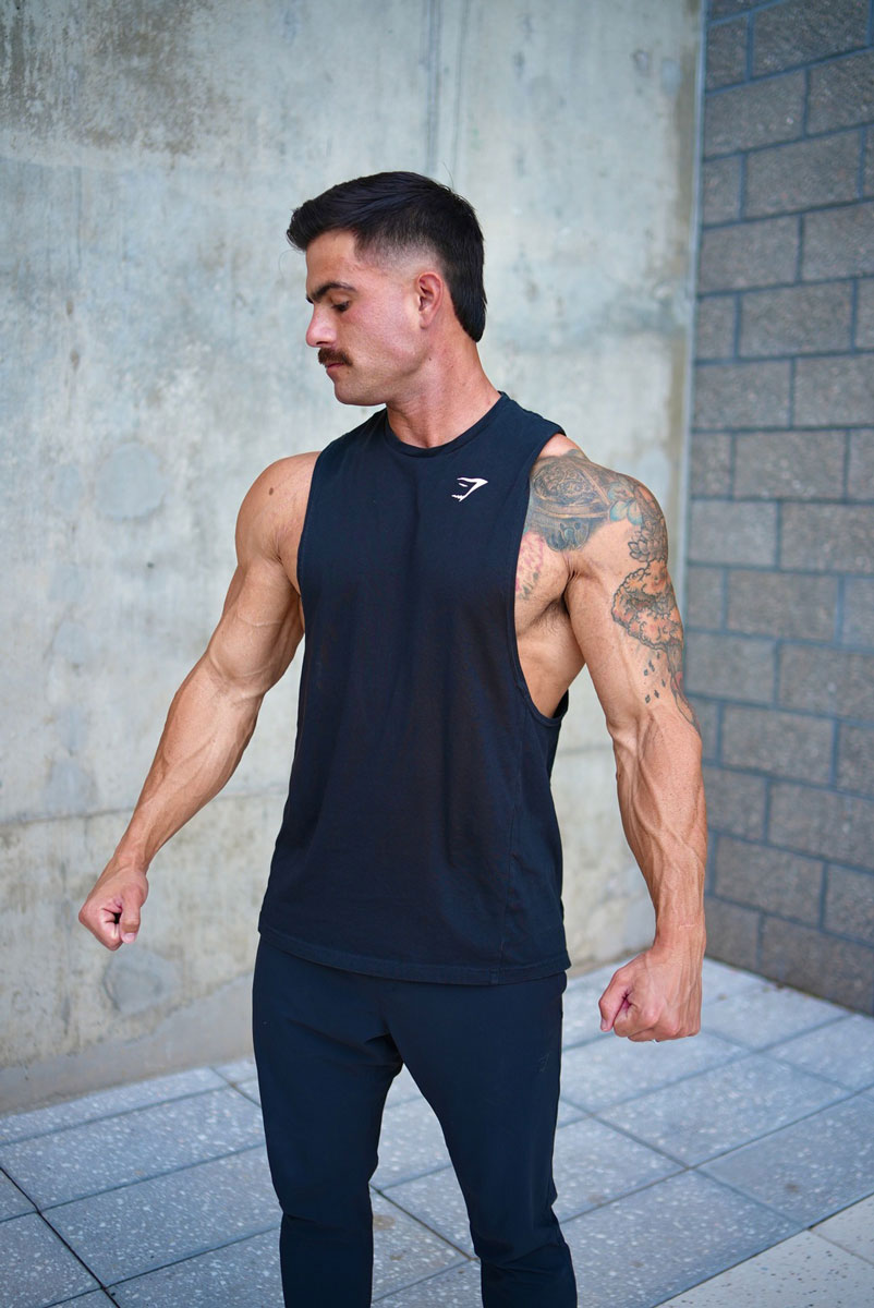 Coach standing in a gym with his earphones.
