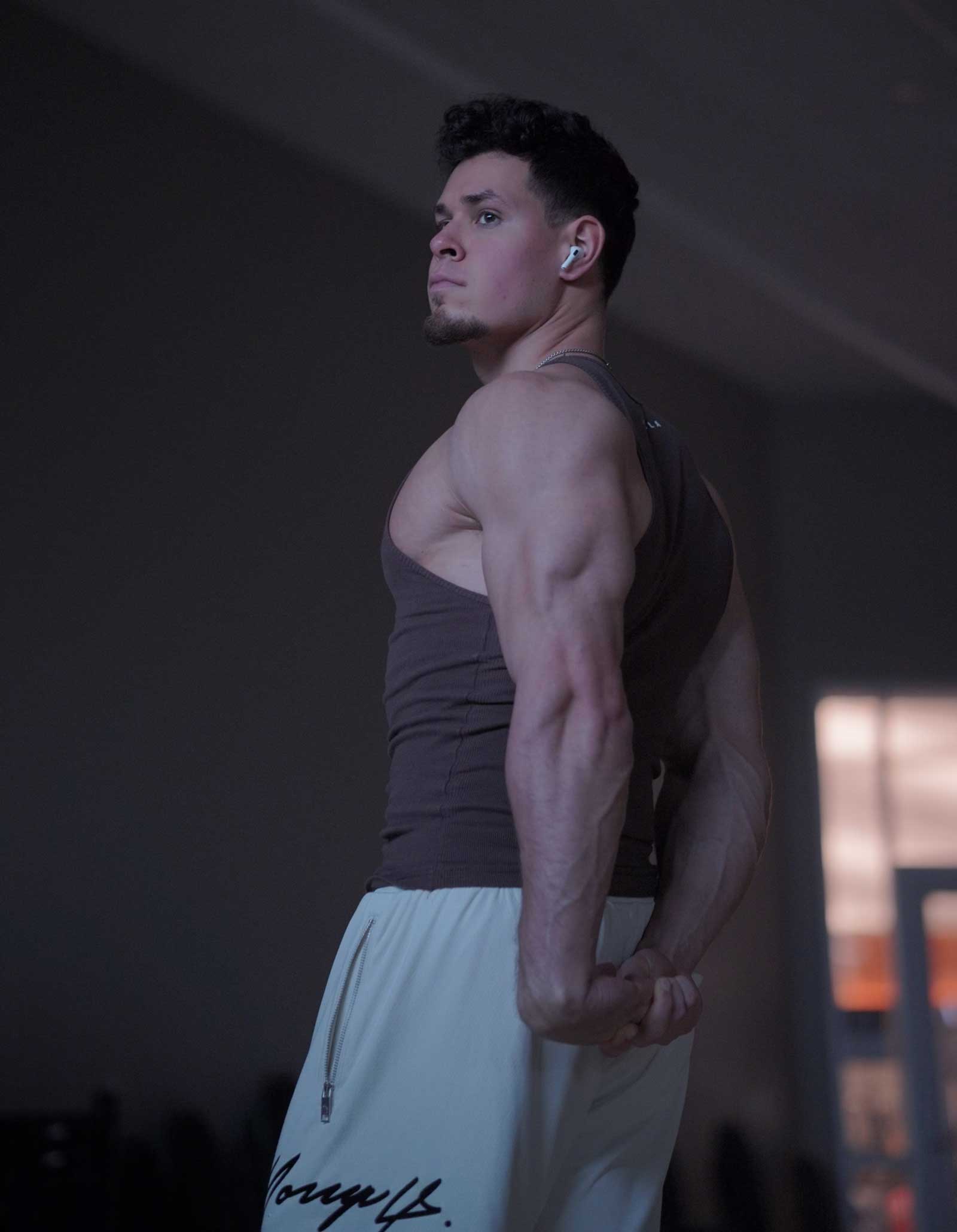 Coach showing arm muscles in a side pose.