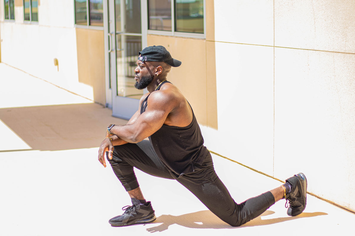 The coach is stretching his body.
