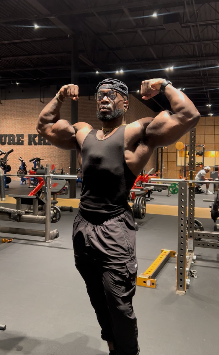 The coach is posing at the gym.
